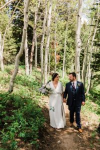 Bride and groom walk among the aspen trees on their wedding day at Grand Targhee Resort by Jackson Hole wedding photographer Amy Galbraith