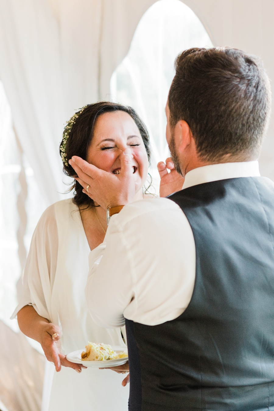 Groom wipes cake off of bride's nose at Grand Targhee wedding