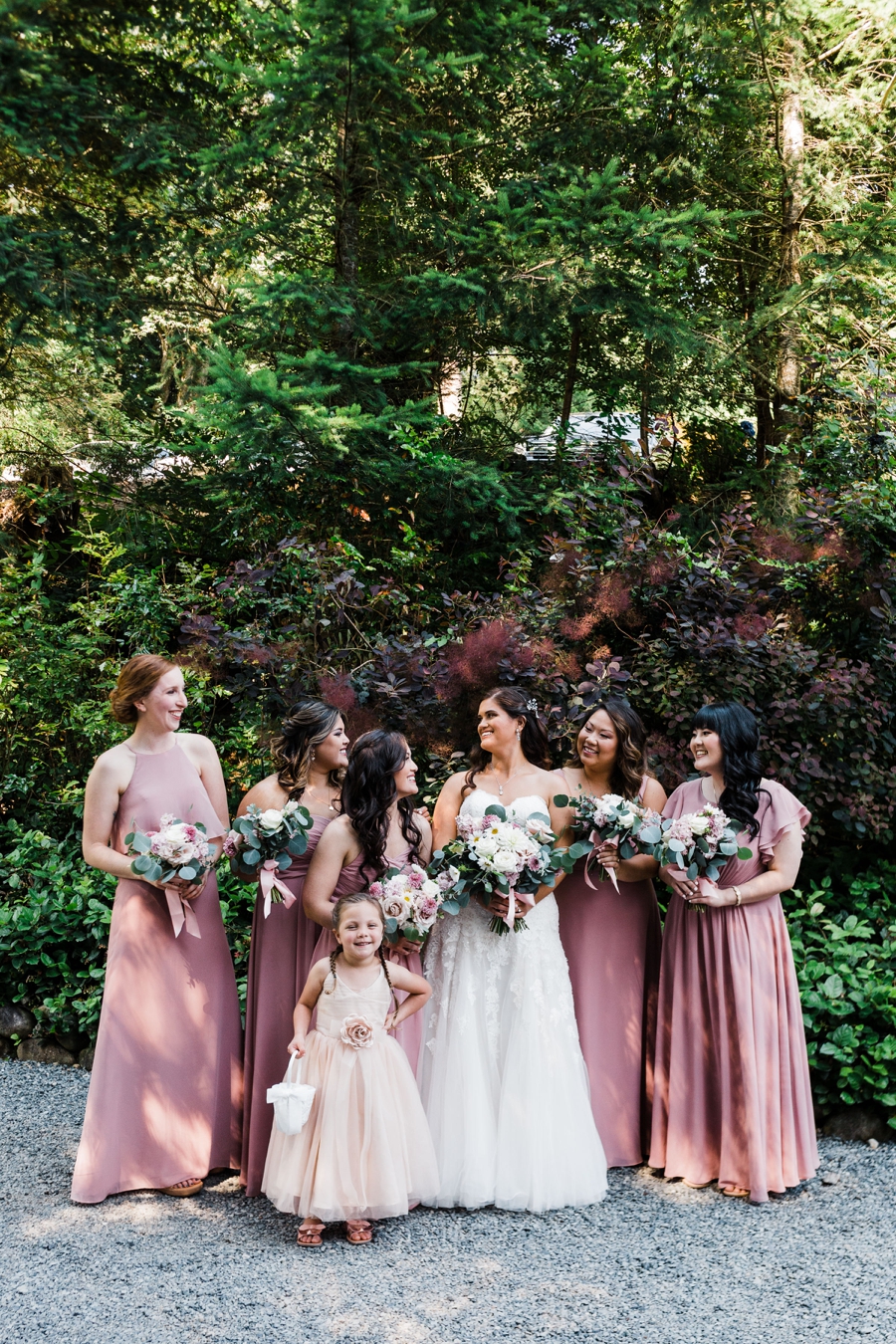 Bridesmaids wearing dusty rose dresses carrying cream and pink wedding bouquets by Seattle wedding photographer Amy Galbraith