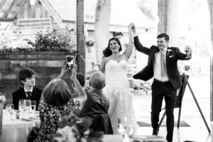 A bride and groom celebrate as they make their grand entrance into their reception