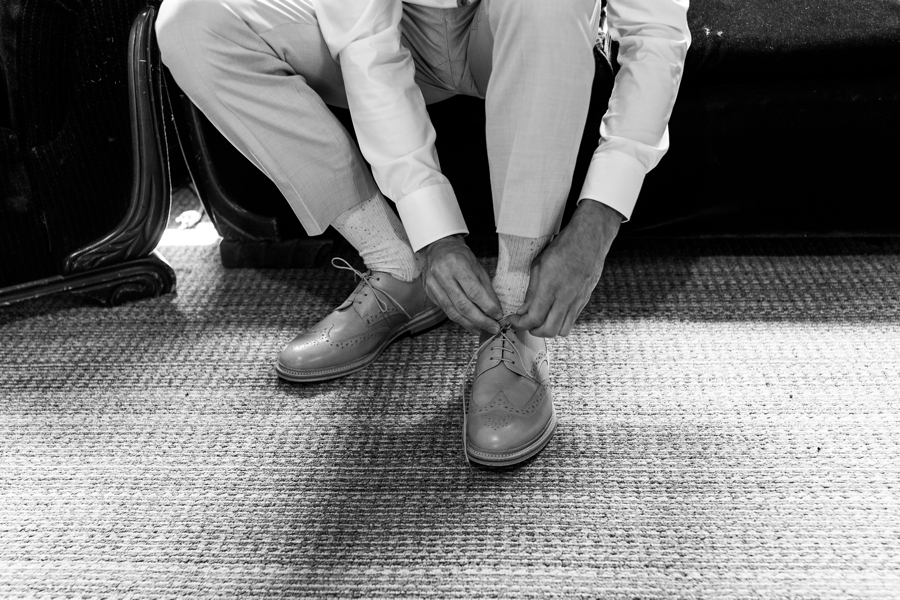 Groom tying a shoes on his wedding day at Brown Family Homestead