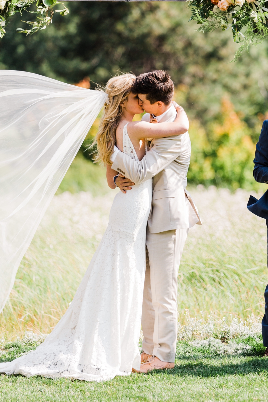 A bride and groom share their first kiss at their wedding ceremony at Brown Family Homestead in Leavenworth, photographed by mountain wedding photographer Amy Galbraith