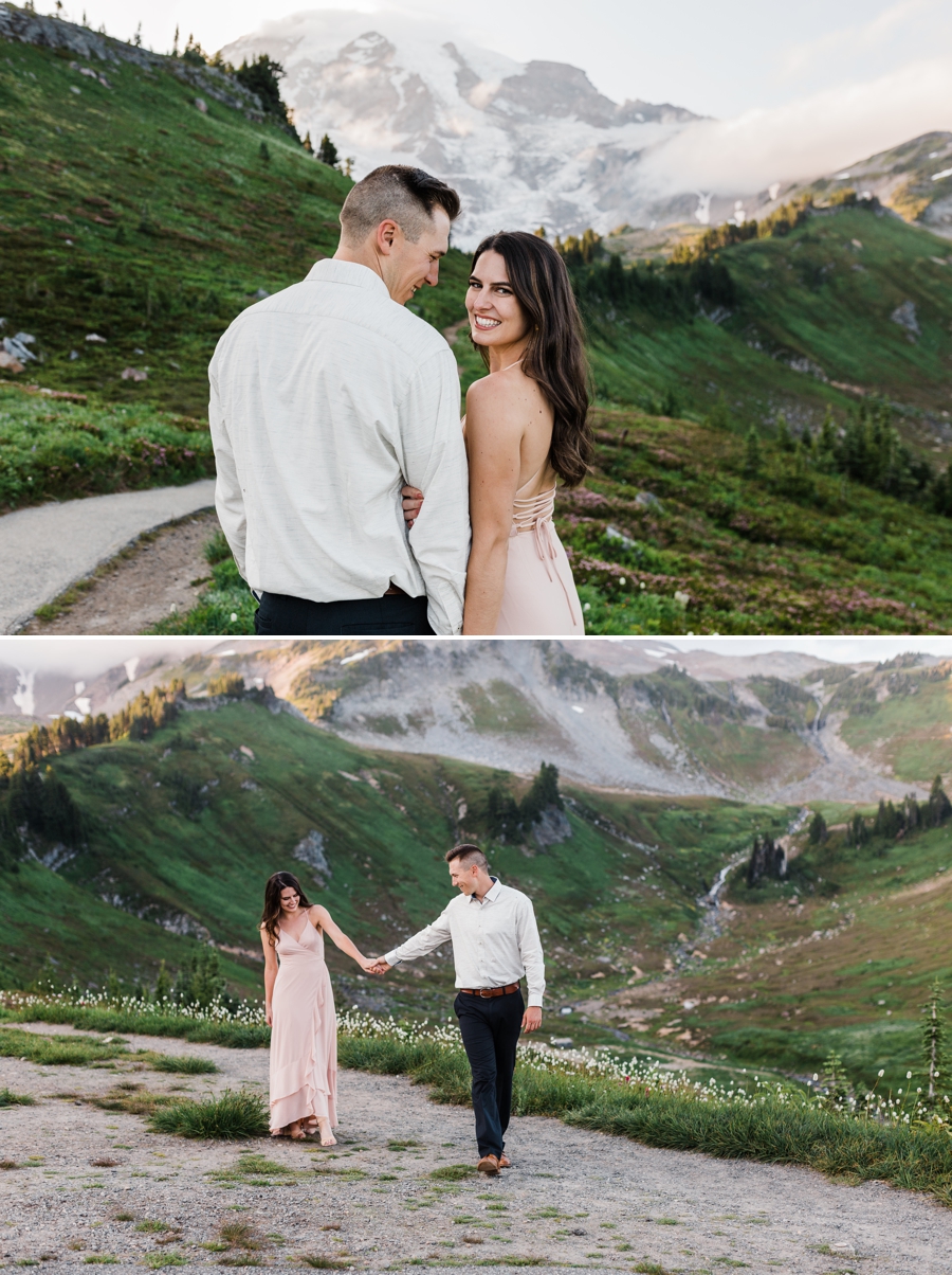 A couple walks along a trail together with Mt Rainier in the background during their engagement session at Mt Rainier