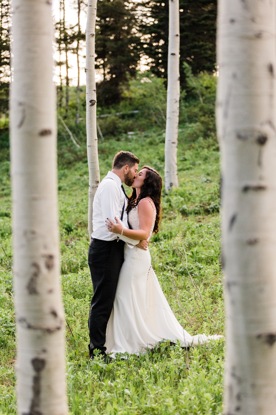 A bride and groom stroll through an aspen grove at Grand Targhee, captured by Jackson Hole wedding photographer Amy Galbraith