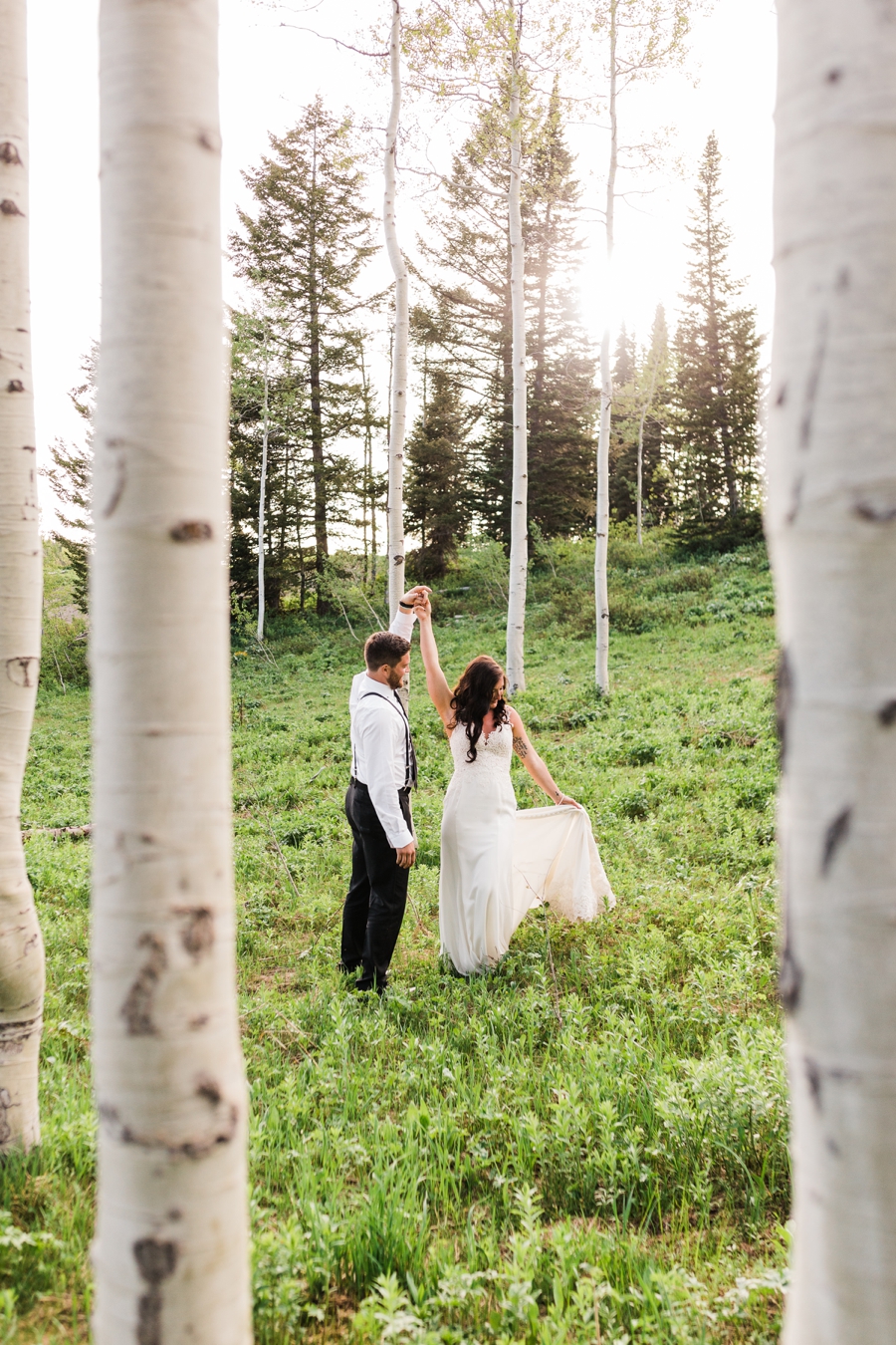 A bride and groom stroll through an aspen grove at Grand Targhee, captured by Jackson Hole wedding photographer Amy Galbraith