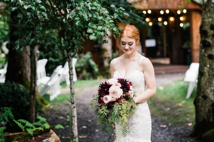 A bride holds a bouquet of seasonal blush and maroon flowers for her bridal bouquet photographed by Seattle mountain wedding photographer Amy Galbraith