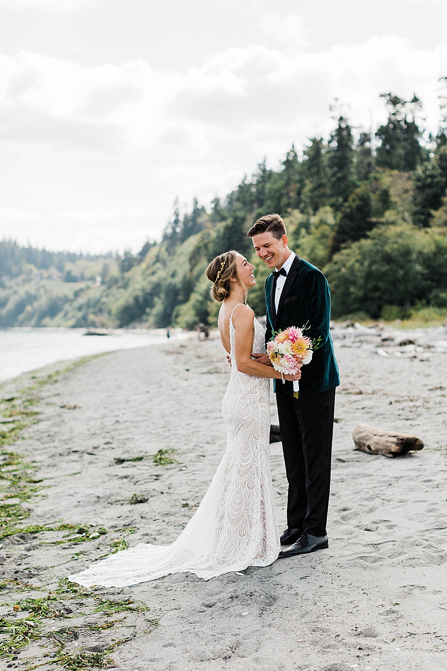 A groom embraces his bride on the beach at Point No Point in Washington, photographed by adventure wedding photographer Amy Galbraith