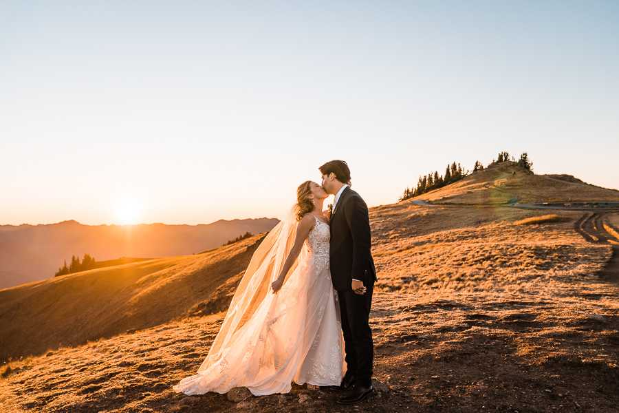 A bride and groom kiss at sunset after hiking up Hurricane Hill after eloping in Olympic National Park