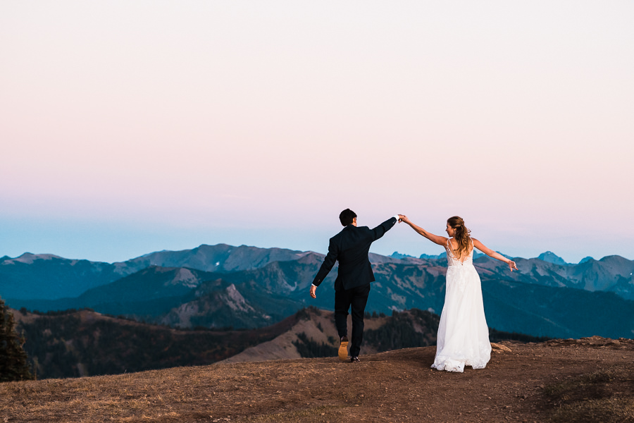 A groom spins his bride on top of Hurricane Ridge at dusk in Olympic National Park