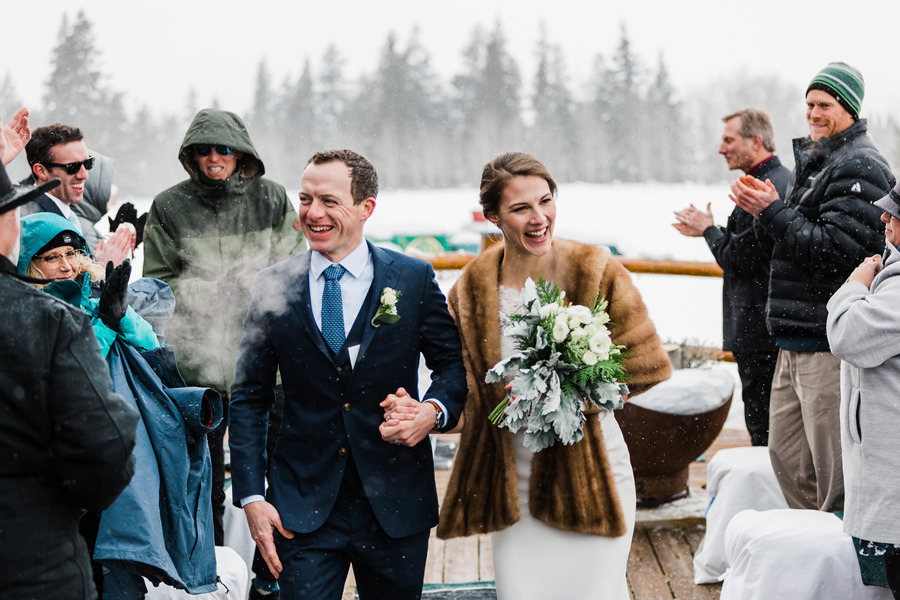 A couple smiles as they finish their walk down the aisle during their small winter elopement in Jackson Hole