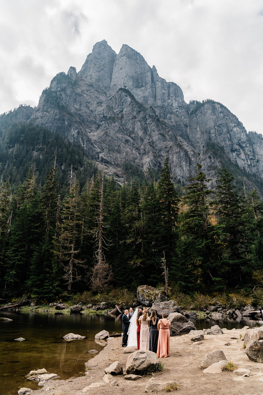 An elopement ceremony takes place next to a towering peak in the Washington backcountry photographed by PNW elopement photographer Amy Galbraith