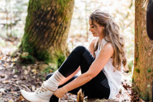 A bride puts on cute white hiking boots before her elopement in the Washington Cascades