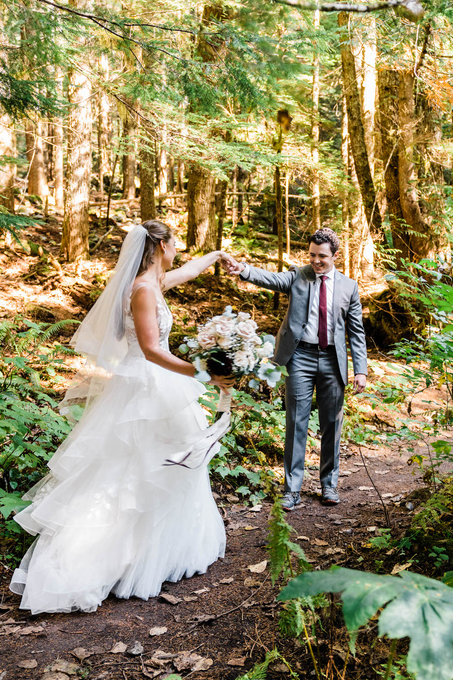 A bride and groom share a first look in the woods near Stevens Pass