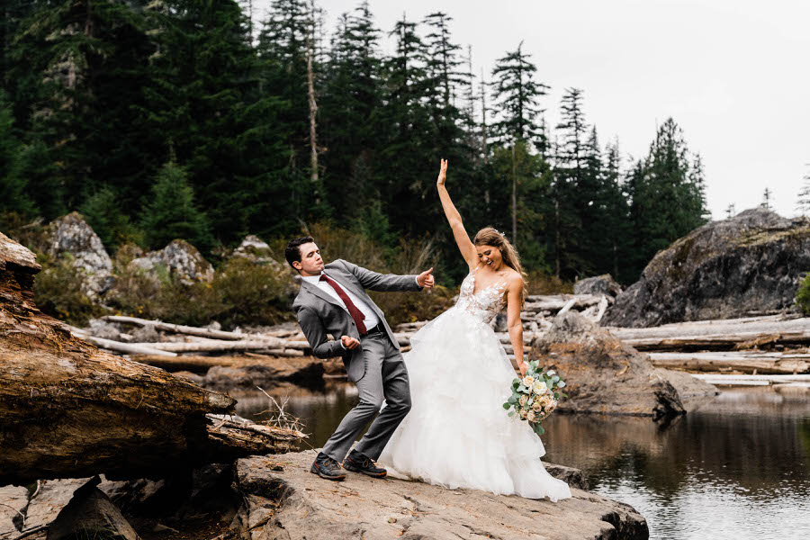 A bride and groom dance together next to a mountain lake after their hiking elopement