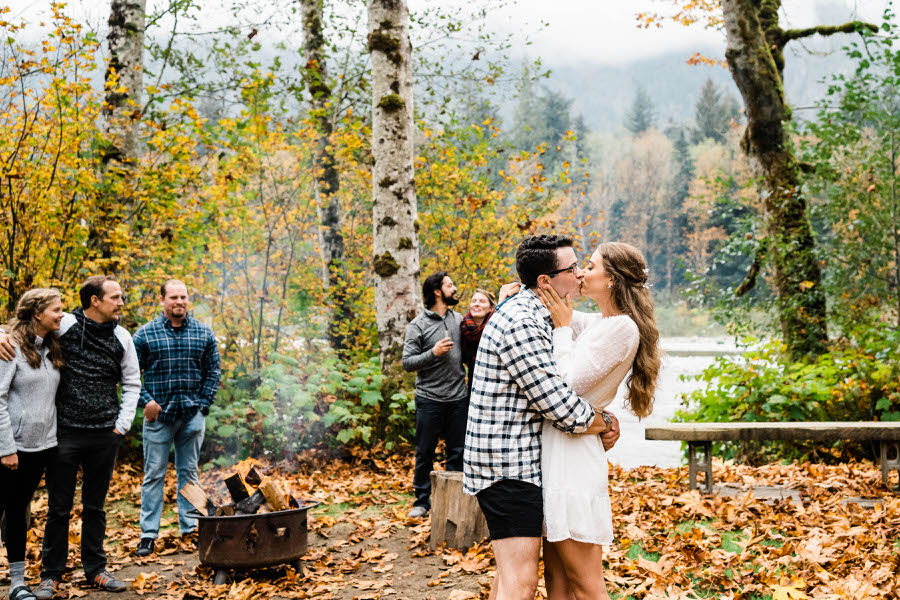 A bride and groom share their first dance next to a fire pit at a cabin in the mountains near Stevens Pass