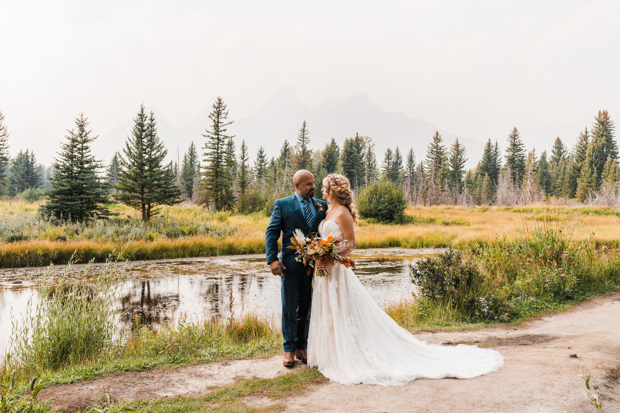 Bride and groom portraits in front of a lake