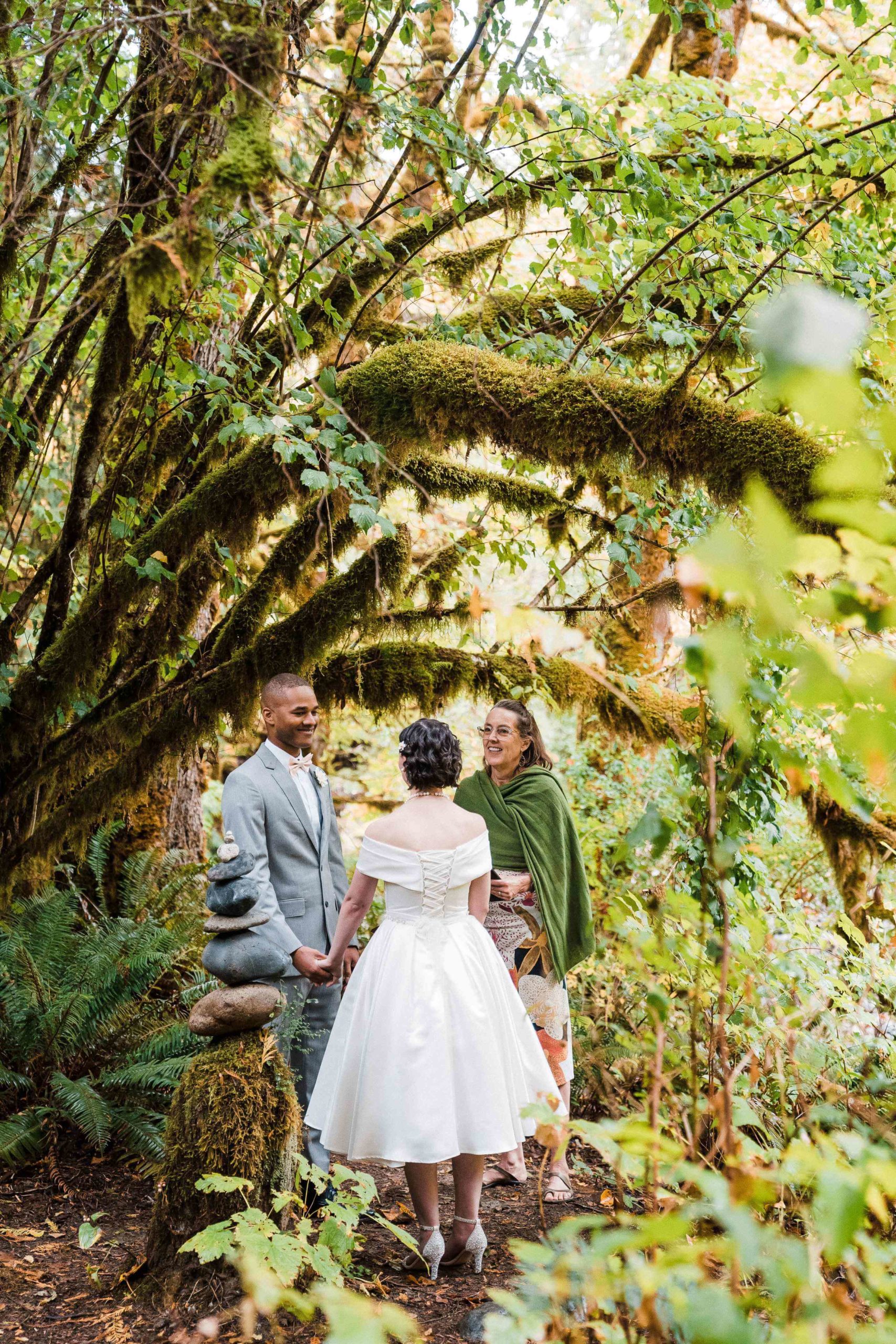 Bride and groom standing under the trees at their forest elopement at Treehouse Point
