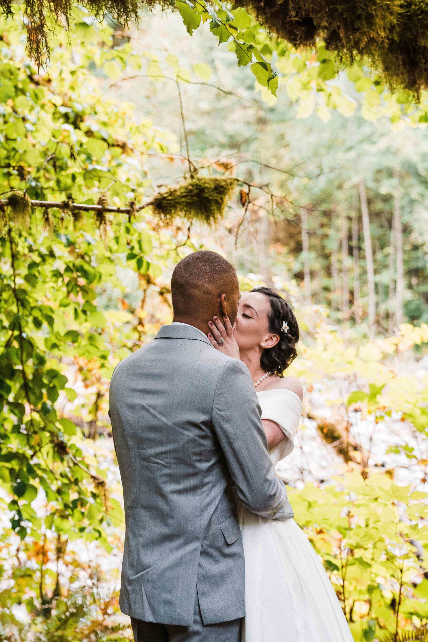 Bride and groom kiss at their forest elopement at Treehouse Point