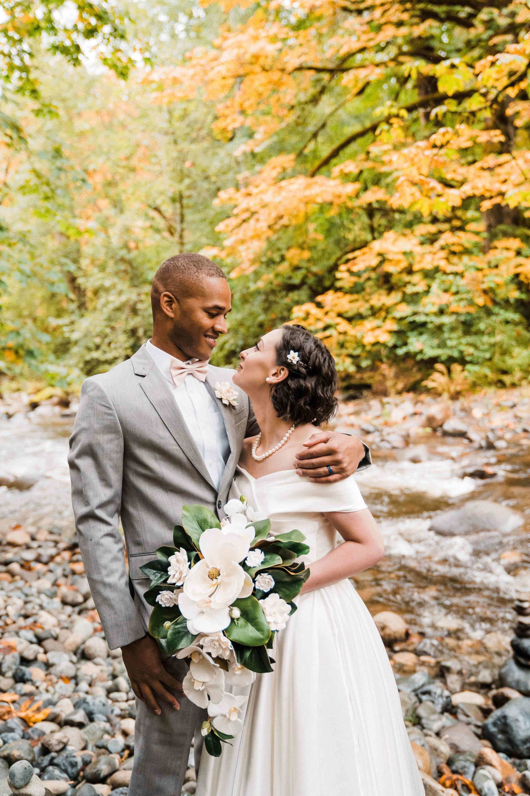 Bride and groom couple portraits by the river at Treehouse Point elopement