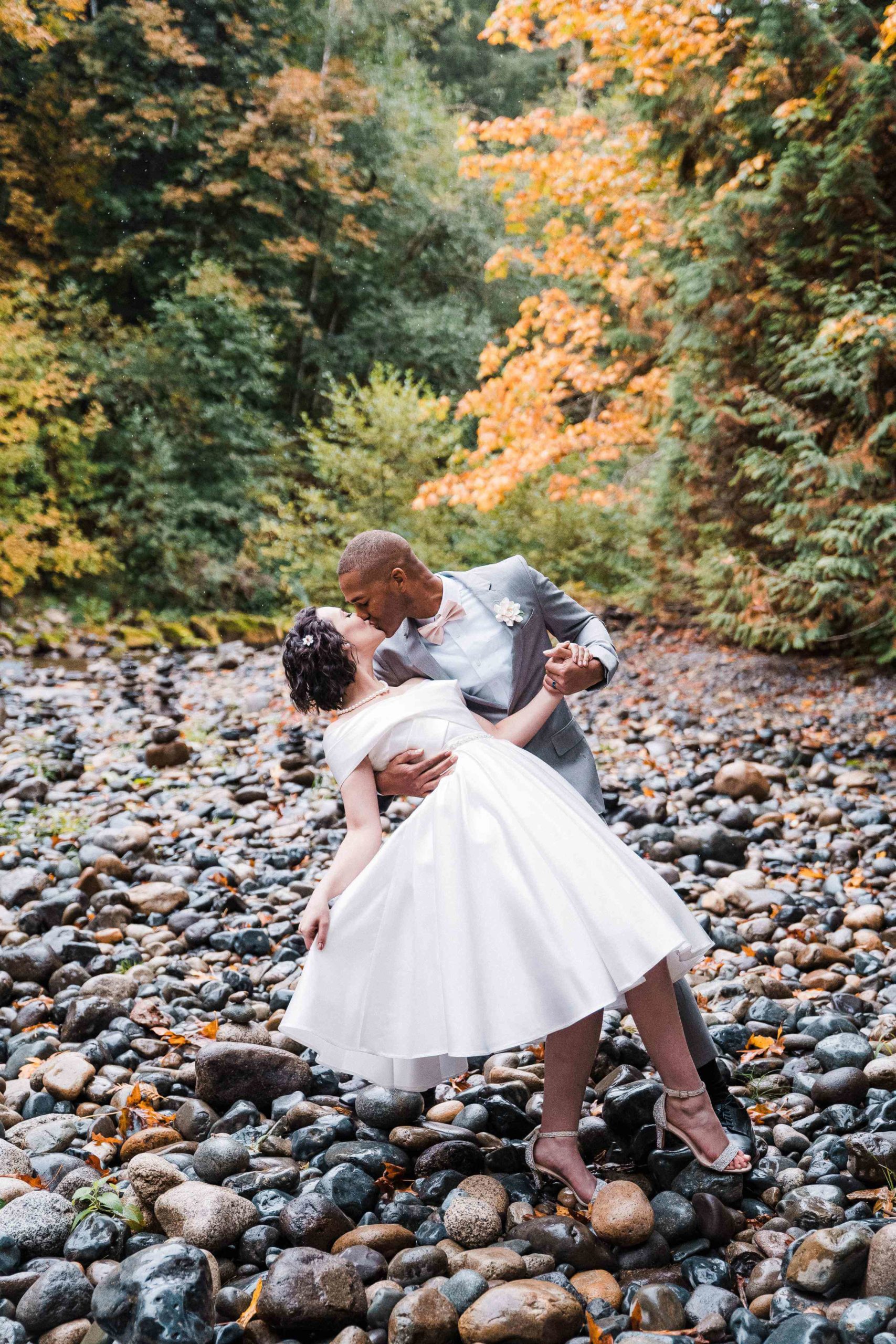 Groom dips bride backwards while kissing her for their Treehouse Point elopement photos