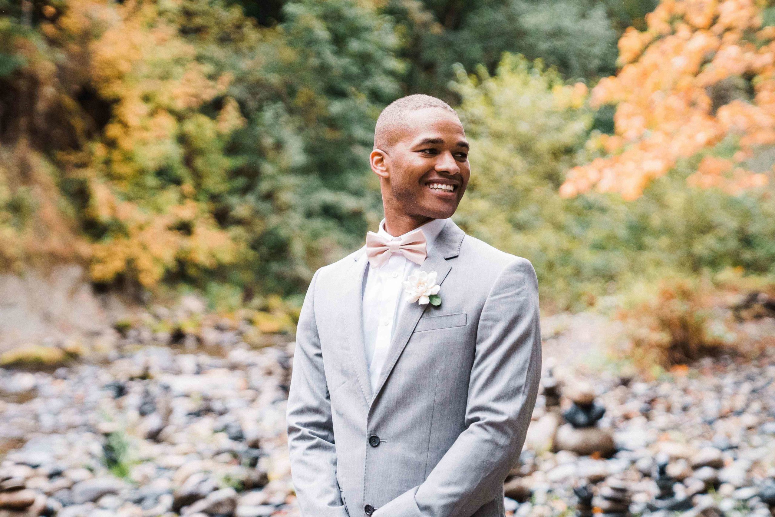Groom smiling for outdoor couple portraits