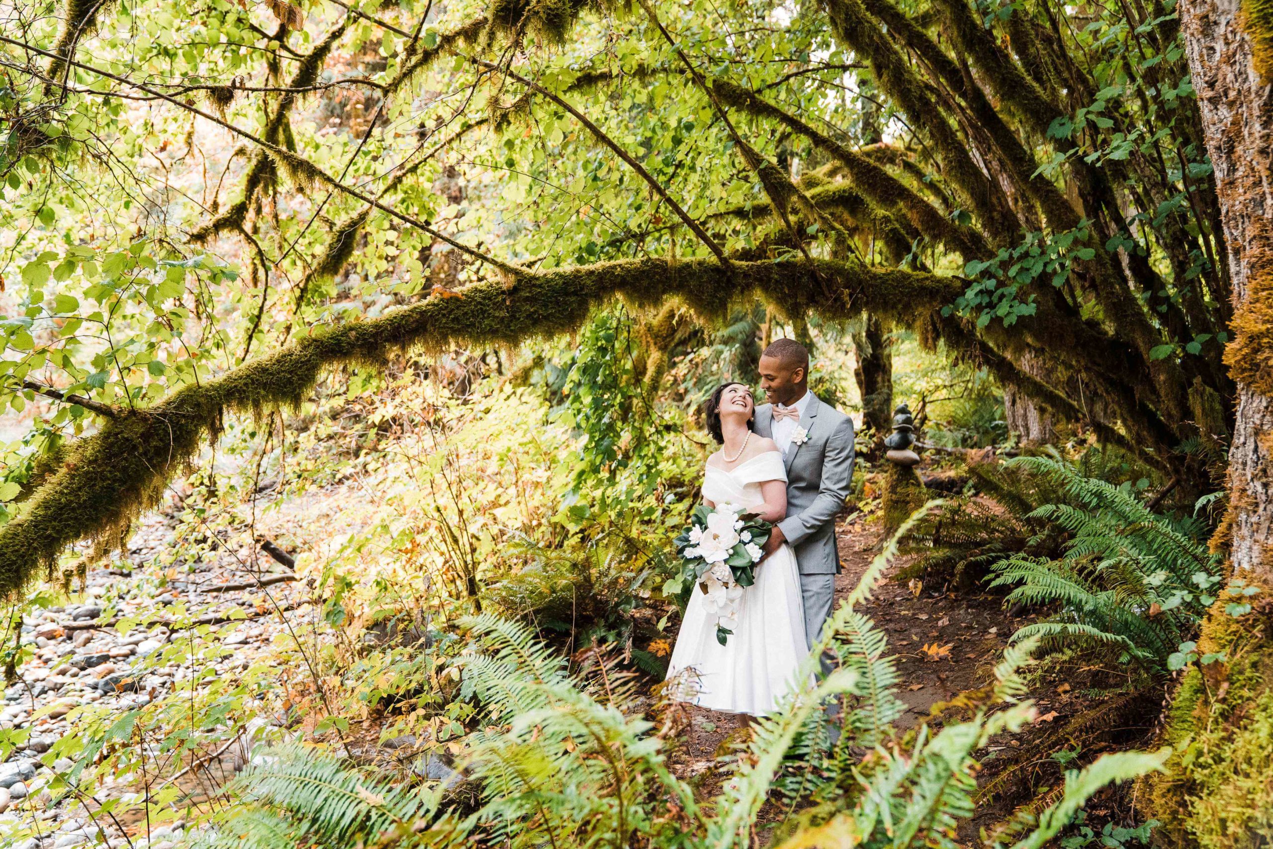 Bride and groom embracing in the forest for their couple photos