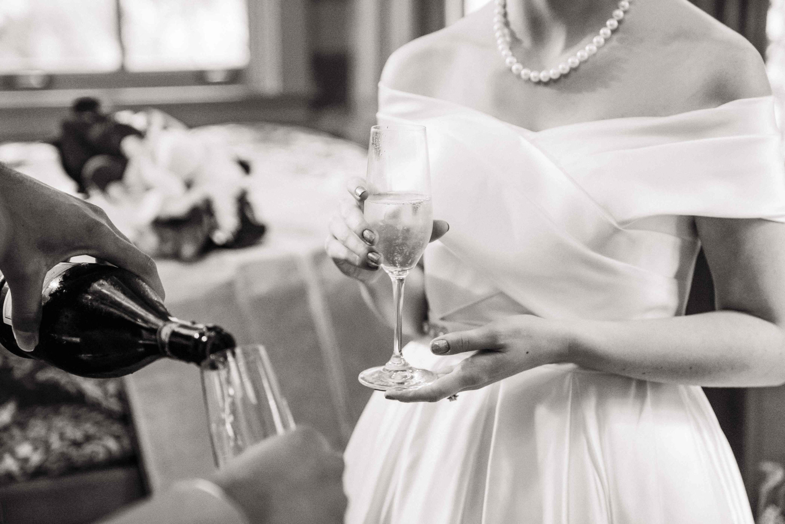 Groom pouring champagne for bride