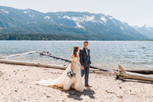Bride and groom walking by the water at Washington mountain wedding