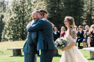 Bride's father hugging the groom at the wedding altar
