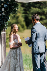 Groom reading vows to bride at outdoor wedding