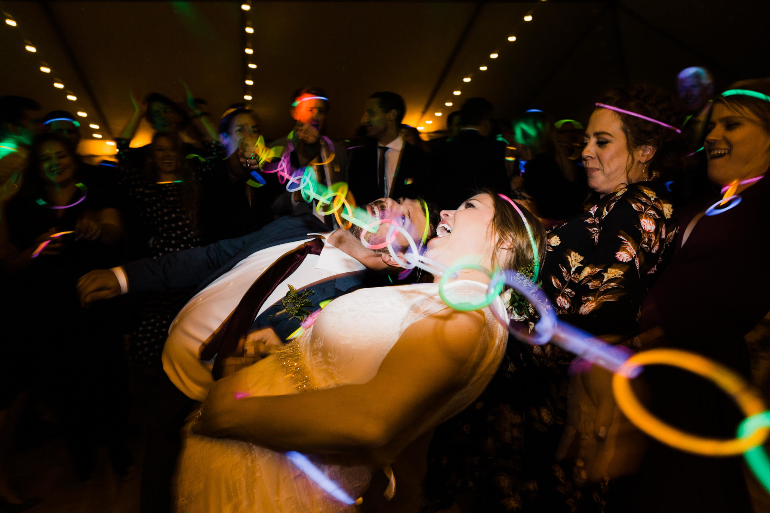 Bride and groom dancing with neon lights at backyard wedding reception