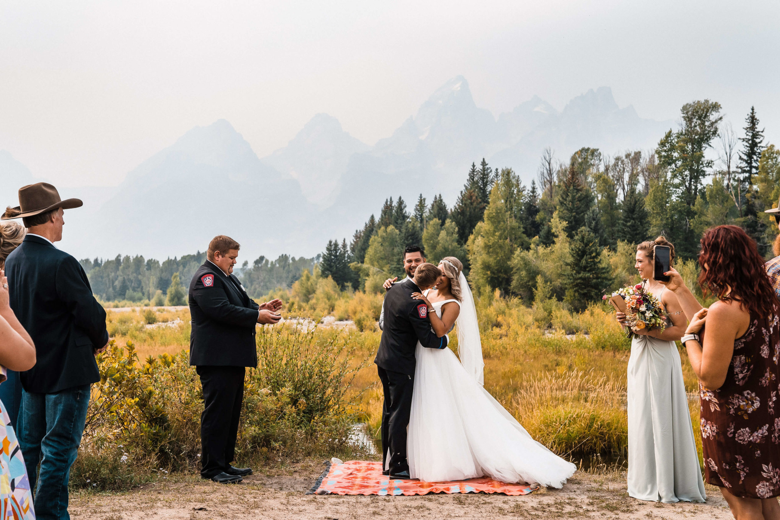 Bride and groom kiss during small summer wedding ceremony in Jackson Hole, Wyoming