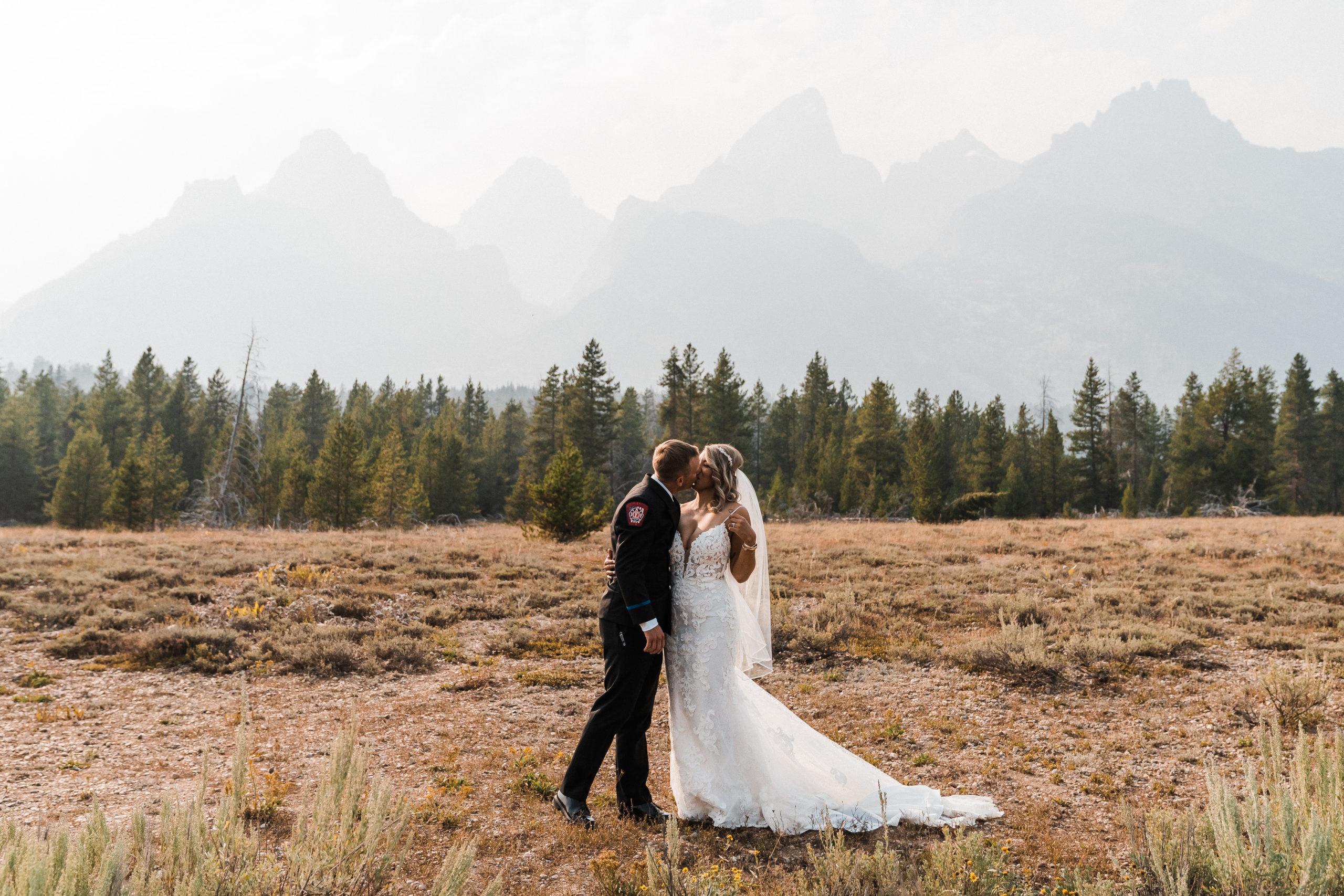 Bride and groom kissing in a field at Grand Teton National Park