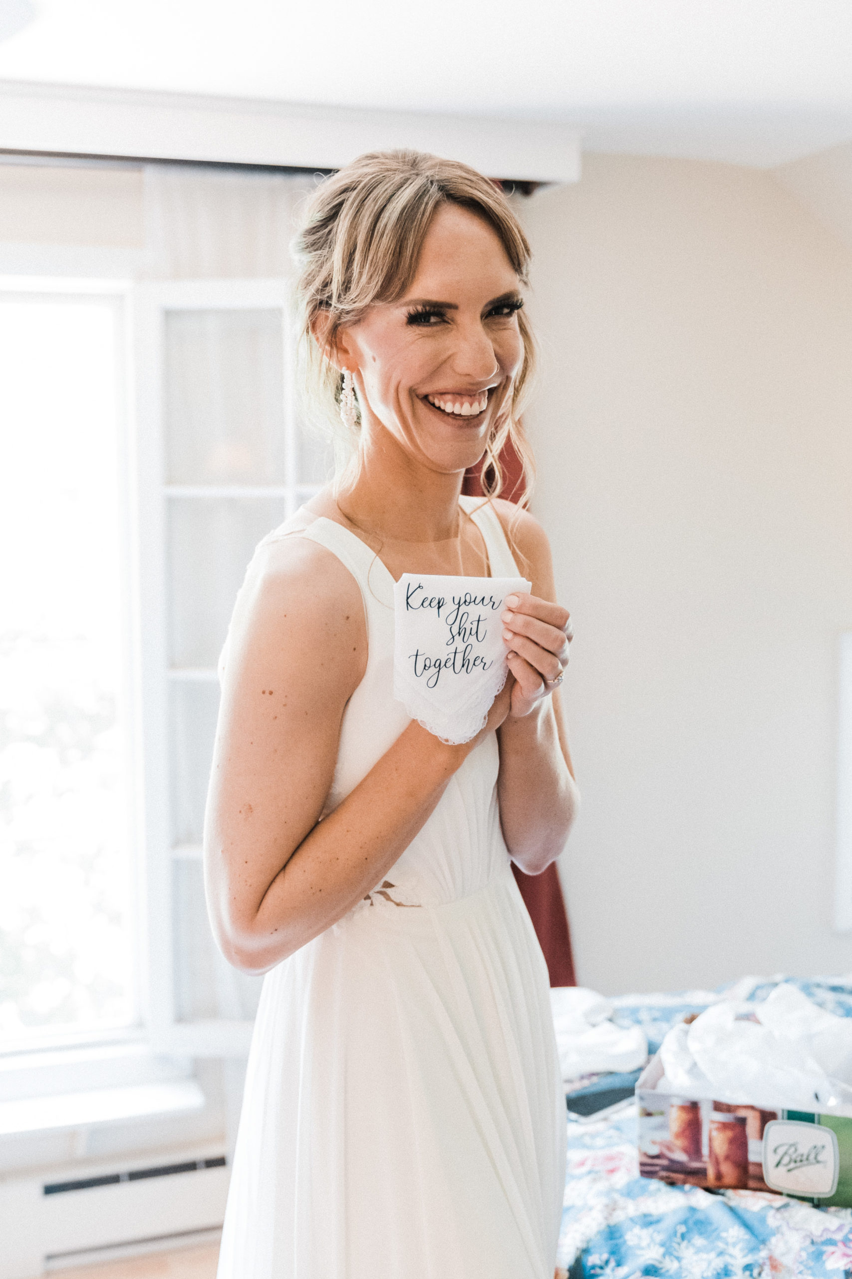 Bride holding personalized embroidered handkerchief while getting ready for intimate wedding in Hood River