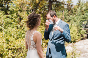 Groom crying and wiping his eyes after first look at Hood River wedding