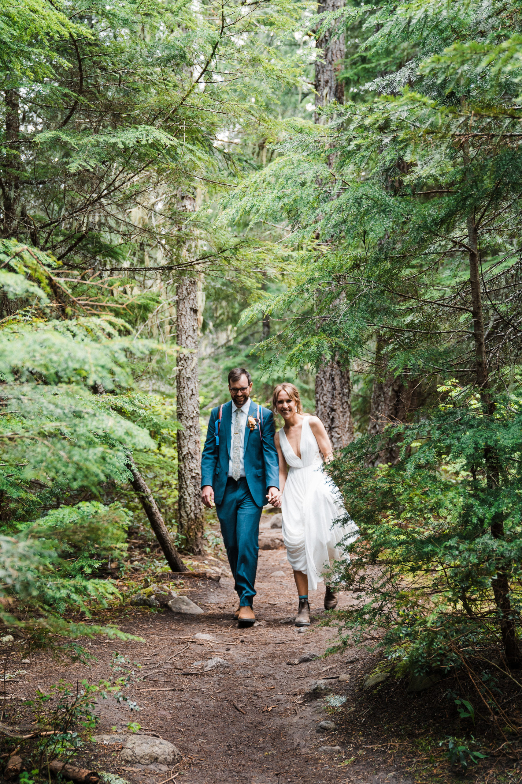 Bride and groom walking a forest trail at hiking wedding in Hood River