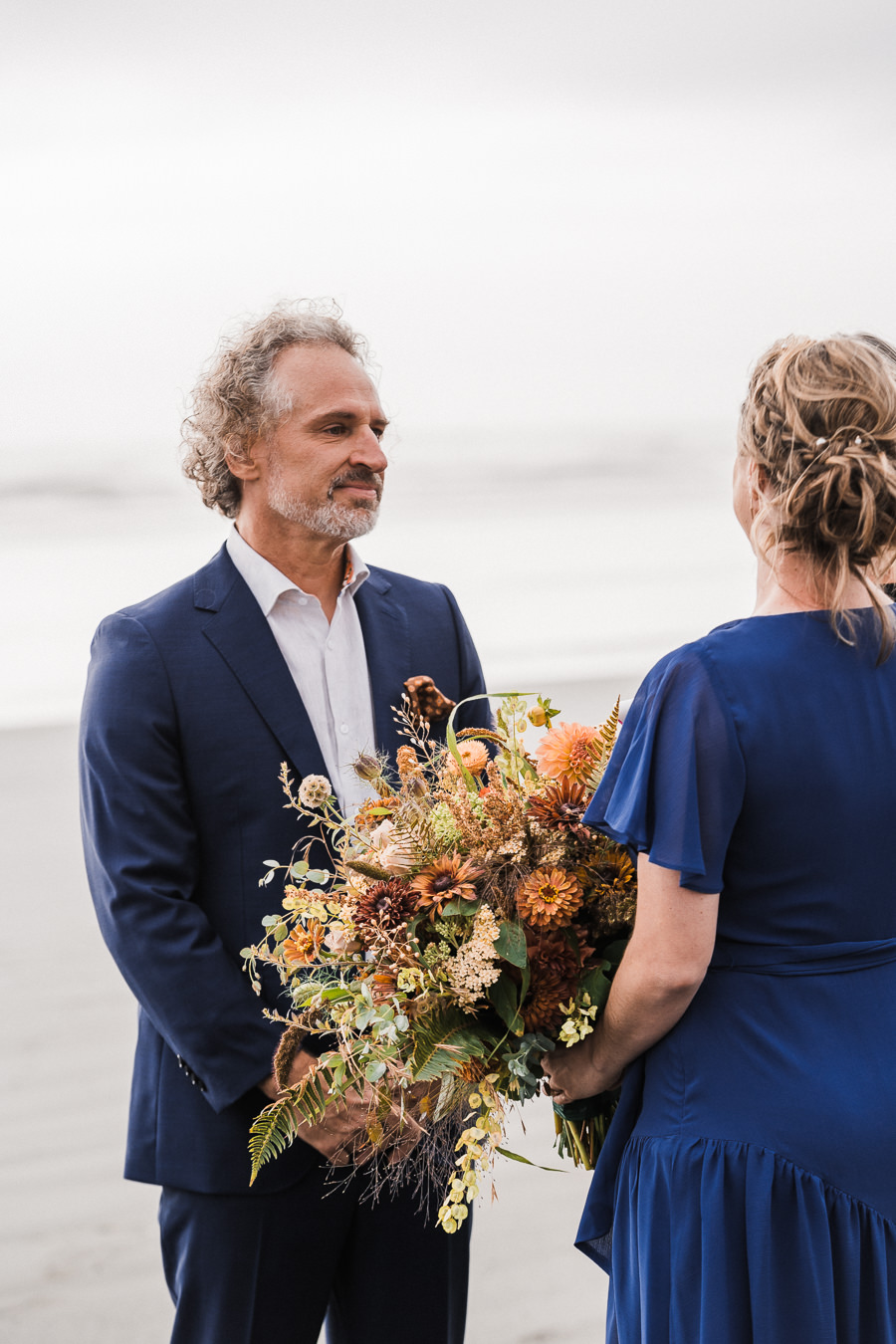 Groom looks at his bride during a ceremony on the Washington coast