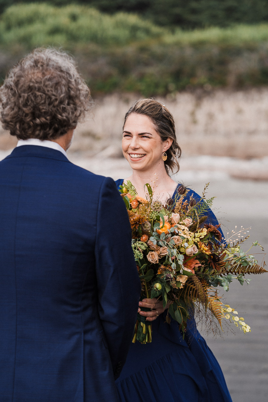 Bride looks at her groom during their elopement ceremony on the Washington coast