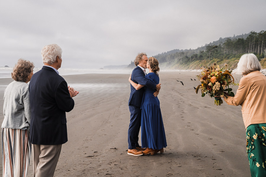 Bride and groom share a first kiss during their elopement ceremony on Kalaloch Beach