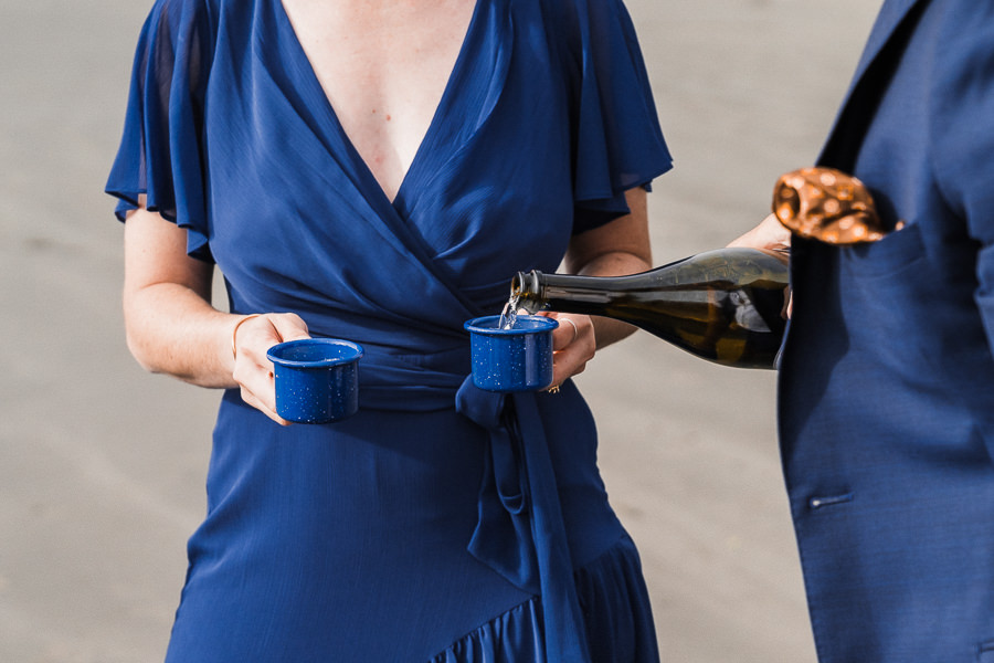 Champagne is poured into miniature blue camp cups