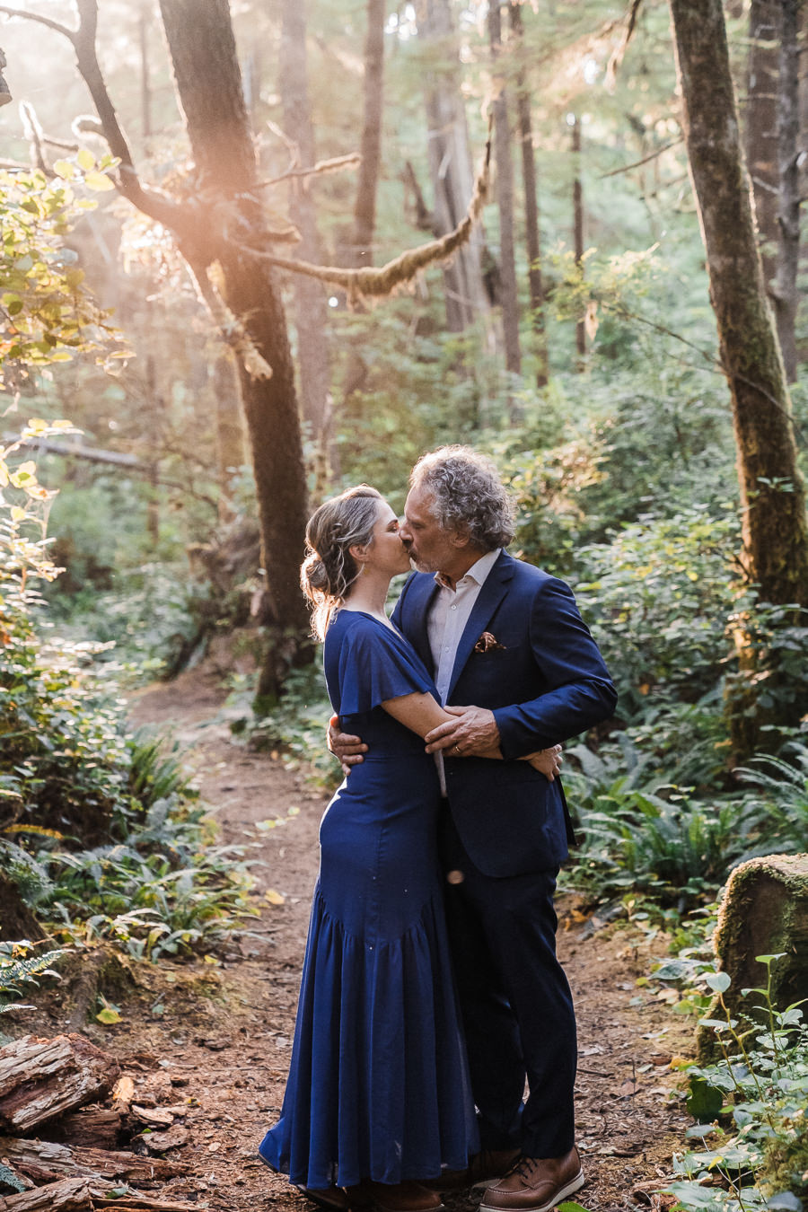Bride and groom share a kiss in the mossy forest in Olympic National Park