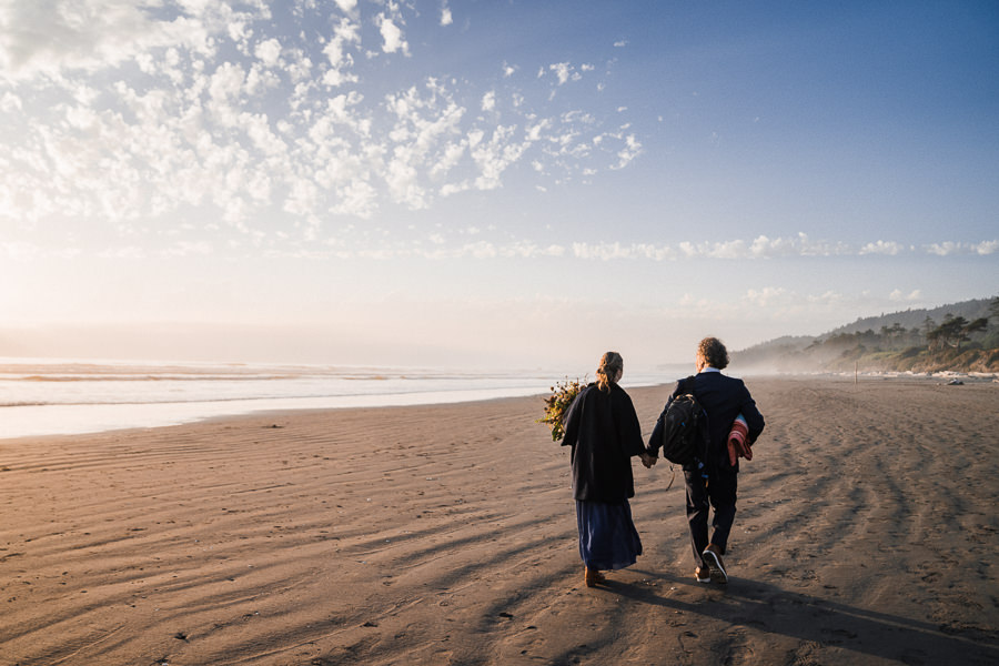 Bride and groom walk on Kalaloch Beach at sunset after their elopement