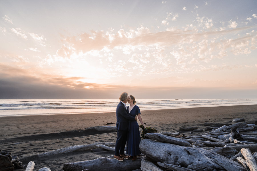 Bride and groom on driftwood on Kalaloch Beach in Olympic National Park