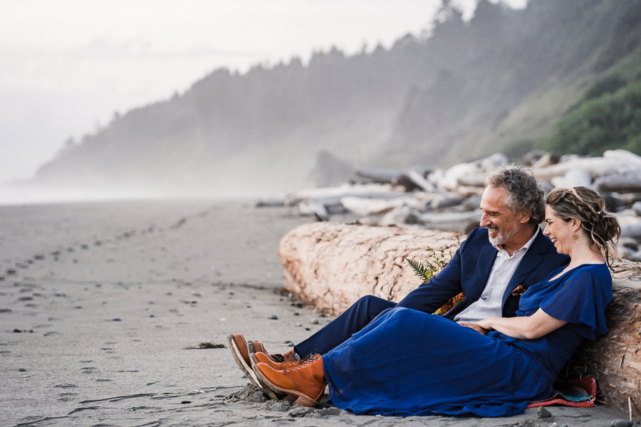Bride and groom laugh together on a misty beach after their Washington coast elopement