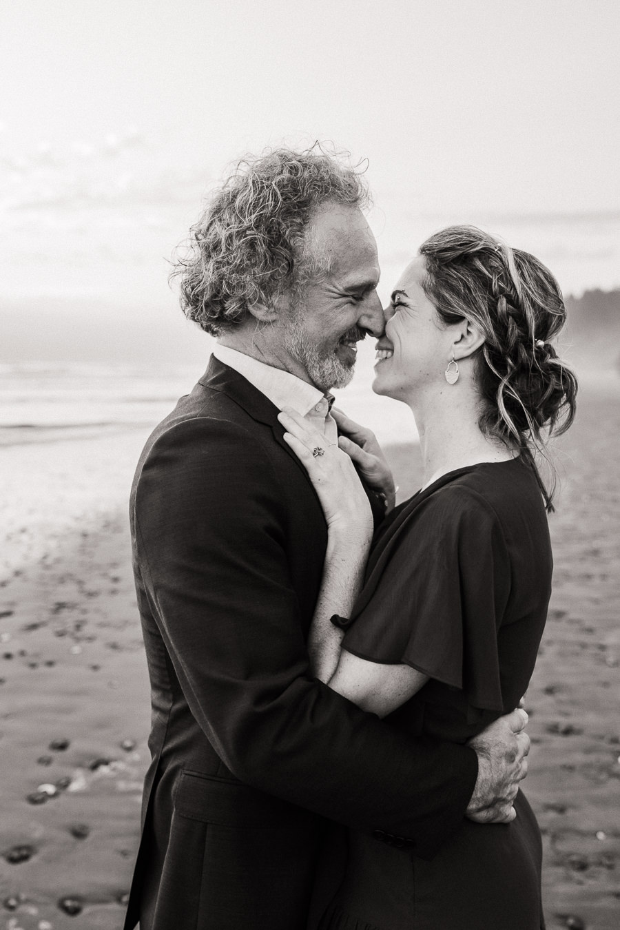 Black and white image of a bride and groom sharing a happy moment together on Kalaloch Beach