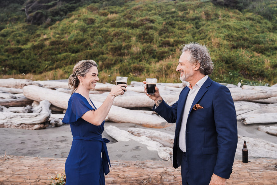Bride and groom toast with a dark beer after their Olympic National Park elopement