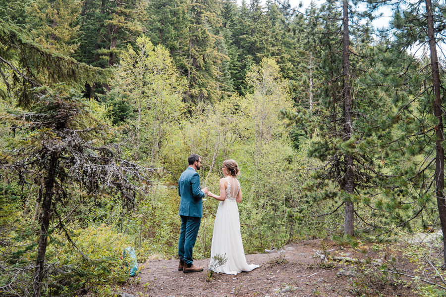 a bride and groom enjoy a quiet moment together by the river in oregon