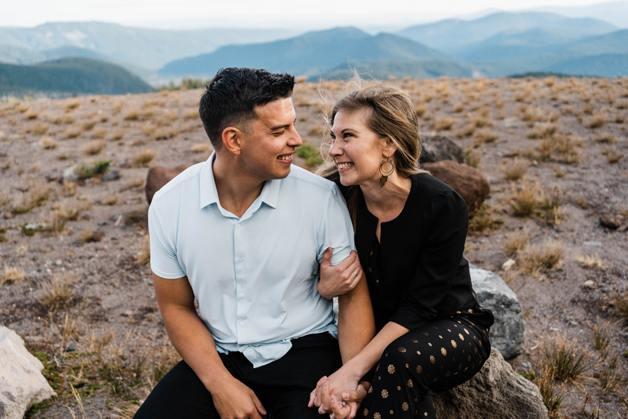 a couple laughs together while sitting on a rock at Mt Hood