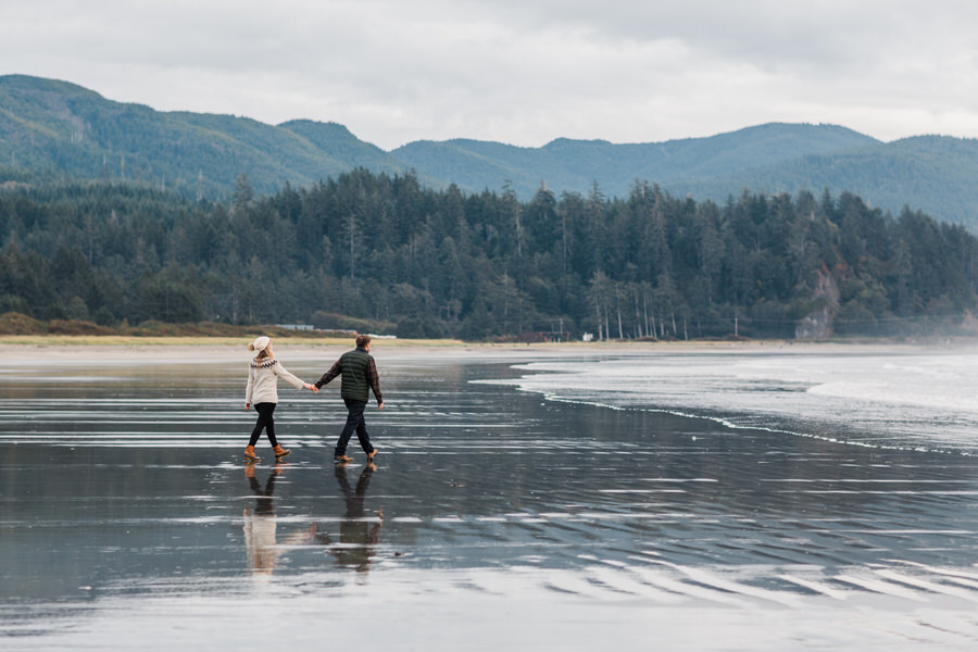 A couple strolls together on the Washington coast during their engagement photos