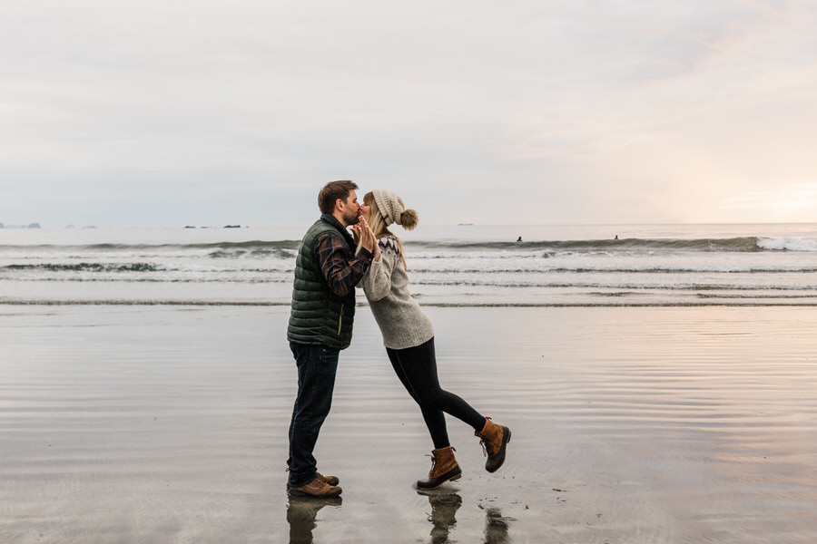 A couple kisses on the Washington coast with the ocean in the background